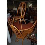 ERCOL DINING SUITE COMPRISING FOUR QUAKER DESIGN CHAIRS AND A CIRCULAR PEDESTAL DINING TABLE