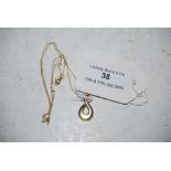 A 9CT GOLD PEAR SHAPED PENDANT WITH PIERCED DETAIL SUSPENDED FROM YELLOW METAL CHAIN