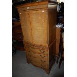 REPRODUCTION WALNUT TWO PART CABINET ON CHEST, THE UPPER SECTION WITH TWO SERPENTINE FRONT