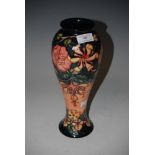 MODERN MOORCROFT POTTERY VASE DECORATED WITH FLOWERS AND FOLIAGE ON A BLUE/PEACH COLOURED GROUND