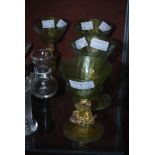 FOUR CONTINENTAL CLEAR, GREEN AND GILT WINE GOBLETS, THE BOWLS SUPPORTED ON MYTHICAL SEA CREATURE