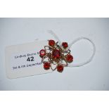 A 9CT GOLD AND GARNET FLOWER SHAPED BROOCH