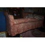 A 20TH CENTURY MAHOGANY FRAMED THREE SEAT SOFA WITH LOOSE FLORAL COVER, ON BUN FEET