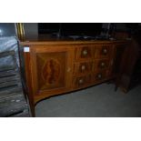 20TH CENTURY MAHOGANY INLAID BOW FRONT SIDEBOARD WITH PANEL DOORS AND CENTRAL BANK OF THREE FRIEZE