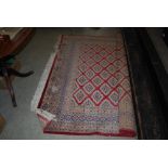 EASTERN PATTERNED RED GROUND CARPET WITH GEOMETRIC DESIGN BORDER AND LARGE CENTRAL PANEL OF