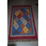 EASTERN PATTERNED RED GROUND KELIM RUG WITH GEOMETRIC DESIGN BORDER AND LARGE CENTRAL PANEL