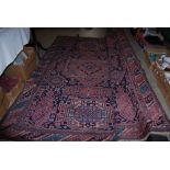 RED GROUND EASTERN PATTERNED CARPET WITH GEOMETRIC DESIGN BORDER AND CENTRAL PANEL OF MIXED FOLIAGE,