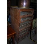 A BANK OF GLAZED FRONT HABERDASHERY DRAWERS IN LATER PLYWOOD FRAME