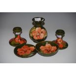 FIVE PIECES OF GREEN GROUND MOORCROFT POTTERY ALL IN THE SAME FLORAL PATTERN, COMPRISING PAIR OF