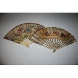 A 19TH CENTURY MOTHER OF PEARL FAN WITH HAND PAINTED PAPER DETAIL OF COURT FIGURES IN A GARDEN,