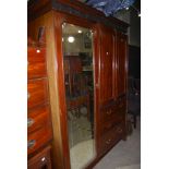 AN EARLY 20TH CENTURY MAHOGANY COMPACT WARDROBE WITH THREE FRIEZE DRAWERS, TWO PANELLED DOORS AND