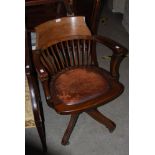 A STAINED OAK CAPTAINS STYLE DESK SWIVEL CHAIR