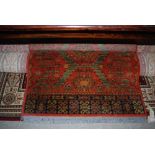 EASTERN RED GROUND FIRESIDE RUG WITH LARGE CENTRAL PANEL OF MEDALLIONS
