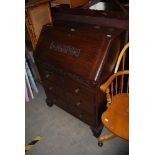 A 20TH CENTURY OAK FALL FRONT WRITING BUREAU ON BRACKET FEET