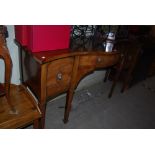 A 19TH CENTURY MAHOGANY SERPENTINE FRONT SIDEBOARD WITH TWO OUTER PANELLED DOORS AND CENTRAL