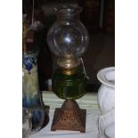 VICTORIAN OIL LAMP WITH CAST IRON BASE, WITH GREEN TINTED GLASS FONT AND GLASS SHADE