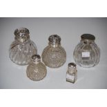FOUR ASSORTED SILVER MOUNTED DRESSING TABLE BOTTLES OF VARYING SIZE, SHAPE AND DESIGN