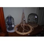 A WIRE AND WOVEN STRAW CONICAL SHAPED HANGING FLOWER BASKET AND TWO BIRD FEEDERS