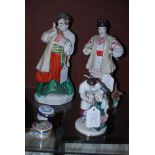 RUSSIAN PORCELAIN FIGURE GROUP OF SEATED FEMALE WITH ATTENDANT MALE HOLDING A PAIR OF GOLDEN