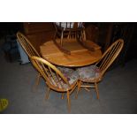 ERCOL EXTENDING KITCHEN TABLE AND FOUR SPINDLE BACK CHAIRS