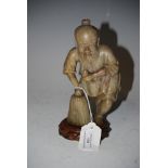 CHINESE SOAPSTONE FIGURE OF A FISHERMAN ON CARVED WOOD STAND