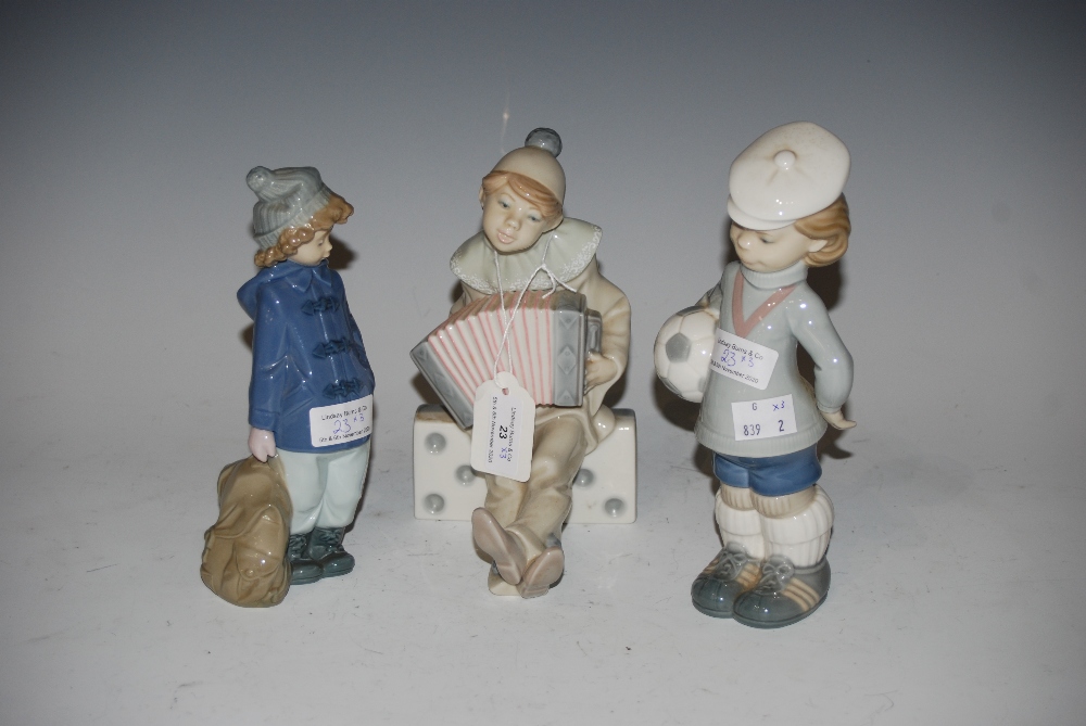 TWO LLADRO FIGURINES - BOY DRESSED AS A CLOWN PLAYING ACCORDION AND BOY CARRYING FOOTBALL,