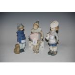 TWO LLADRO FIGURINES - BOY DRESSED AS A CLOWN PLAYING ACCORDION AND BOY CARRYING FOOTBALL,