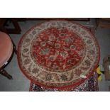 CIRCULAR MADDER GROUND FIRESIDE RUG, TOGETHER WITH A MACHINE MADE MADDER GROUND RUG