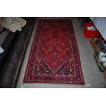 PERSIAN MADDER GROUND RUG CENTRED WITH LOZENGE SHAPED MEDALLION ENCLOSING STYLISED FLOWERS AND