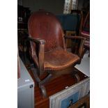 EARLY 20TH CENTURY STAINED BEECH AND LEATHER UPHOLSTERED TUB CHAIR WITH HERALDIC CREST OF LION