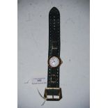 A 9CT GOLD CASED LADIES WRIST WATCH WITH WHITE ARABIC NUMERAL DIAL, ON GREEN SUEDE STRAP WITH YELLOW