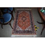PAIR OF ORANGE GROUND PERSIAN RUGS WITH CENTRAL BLUE MEDALLION IN A BORDER OF FLOWERS AND FOLIAGE,