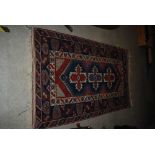 PERSIAN BLUE GROUND RUG, THE RECTANGULAR FIELD CENTRED WITH THREE STYLISED FOLIATE MEDALLIONS IN A