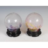 Two Monart night lights, one mottled opaque white, yellow, purple and green, on ebonised plinth,