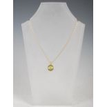 An 18 carat yellow gold pendant set with a single circular cabochon peridot, on 18 carat gold chain,