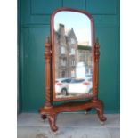 A Victorian mahogany cheval mirror, the arched mirror plate enclosed by tapered cylindrical