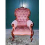 A Victorian mahogany parlour chair, the pink velvet upholstered button down back, arms and seat