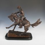 After Frederic Remington (1861-1909), a bronze figure of cowboy and horse, signed Frederic