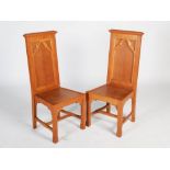 A pair of early 20th century oak Gothic presentation altar chairs, the rectangular panelled backs