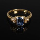 An 18 carat yellow gold sapphire and diamond set cocktail ring, centred with an emerald cut
