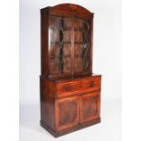 A George III mahogany and boxwood lined secretaire bookcase, the arched cornice centred with a