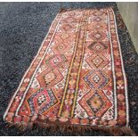 A Kelim long rug, 20th century, the chocolate coloured ground decorated with sixteen square shaped