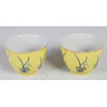 A pair of Chinese porcelain yellow ground footed bowls, bearing four character Tongzhi marks and