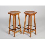 Mouseman - A pair of oak bar stools, the dished rounded rectangular tops raised on four splayed