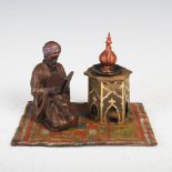 A cold painted bronze inkwell in the manner of Franz Bergman, in the form of an Arab kneeling and