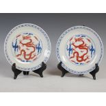 A pair of Chinese porcelain blue and white dragon dishes, 19th/20th century, the interiors with