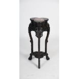 A Chinese dark wood urn stand, Qing Dynasty, the trefoil shaped top centred with a circular marble