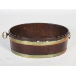 A George III mahogany and brass bound oval shaped cellarette, with brass drop handles to the
