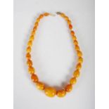 A graduated butterscotch amber necklace, formed from thirty graduated oval beads, together with