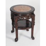 A Chinese dark wood urn stand, Qing Dynasty, the circular top with a mottled red and white marble